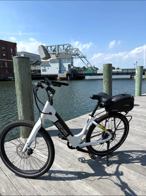 A white Coastal Current step-through e-bike at the Mystic River drawbridge